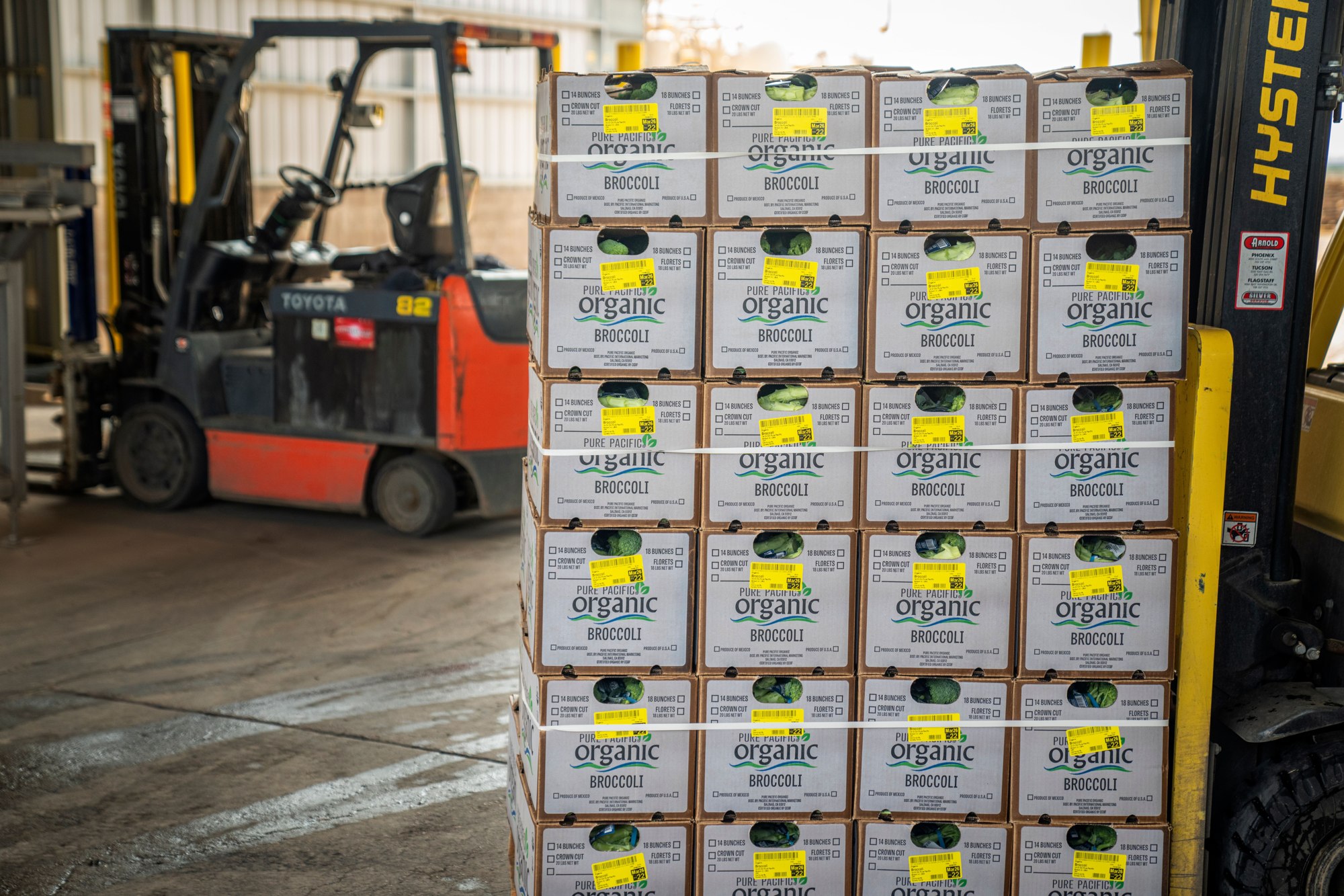 Forklift beside stacked cartons in a warehouse